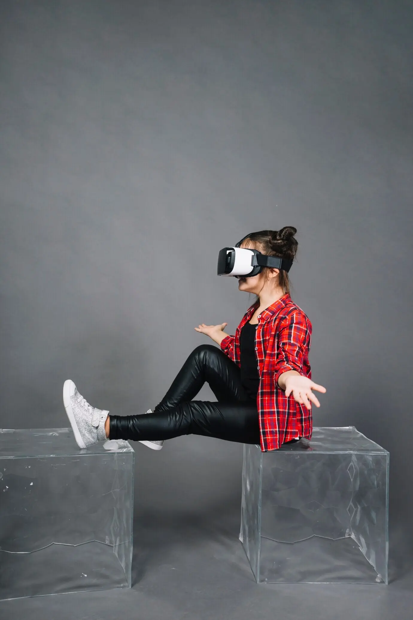 Вид сбоку: девушка в очках виртуальной реальности пожимает плечами.